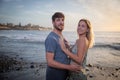 Couple of lovers at the beach during sunset hug and fall in love. Attractive boy and girl cuddling. Partners have fun at the beach Royalty Free Stock Photo