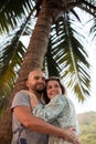 Couple of lovers hug under palm tree while relaxing in tropical paradise. Love and happiness. Tourism and travel. Royalty Free Stock Photo