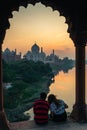 Couple of lovers inside marble arch view at taj mahal at sunset Royalty Free Stock Photo