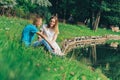 A couple of lovers on a lake in a romantic park.A happy young couple, a guy and a girl sitting on the grass near a river Royalty Free Stock Photo