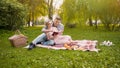 Couple of lovers reading novel book sitting on rug during picnic, romantic date Royalty Free Stock Photo