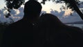 Couple of lovers sitting together on beach cost and looking far at ocean horizon and sunset sky. Media. Boy and girl Royalty Free Stock Photo