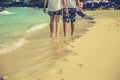 Couple of lovers walking on the each at sunrise - Foot prints the beach