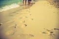 Couple of lovers walking on the each at sunrise - Foot prints the beach