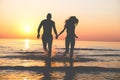 Couple of lovers walking inside water on tropical beach in summer vacation at sunset - Young people enjoying holidays - Love, Royalty Free Stock Photo