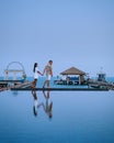 Couple on luxury vacation in Thailand, men and woman infinity pool looking out over the ocean Royalty Free Stock Photo