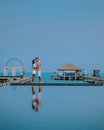 Couple on luxury vacation in Thailand, men and woman infinity pool looking out over the ocean