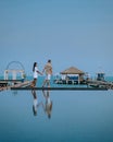 Couple on luxury vacation in Thailand, men and woman infinity pool looking out over the ocean