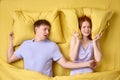 Couple lying in bed, redhead woman is trying to sleep while man is snoring Royalty Free Stock Photo