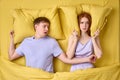 Couple lying in bed, young woman is trying to sleep while man is snoring Royalty Free Stock Photo