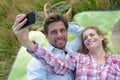 couple lying on blanquet makes selfie