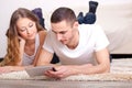Couple lying on carpet and looking at tablet Royalty Free Stock Photo