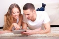 Couple lying on carpet and looking at tablet Royalty Free Stock Photo
