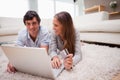 Couple lying on the floor shopping online Royalty Free Stock Photo