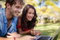 Couple lying on grass and using laptop Royalty Free Stock Photo