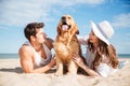 Couple lying and having fun with dog on the beach Royalty Free Stock Photo