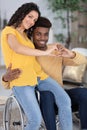 couple make heart gesture with hands man in wheelchair