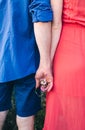 Couple makes a selfie while lying on the grass in flowers. Rest, lovers on a flower meadow. Bearded man and a girl in a red dress Royalty Free Stock Photo