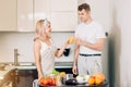 Couple making fresh organic juice in kitchen together