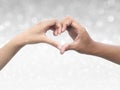 Couple making heart shape with hand on shining bokeh background Royalty Free Stock Photo