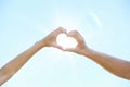 Couple making heart shape with hands against blue sky Royalty Free Stock Photo