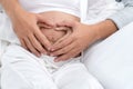 couple making heart shape on the pregnant belly with their hands. Pregnant woman and her husband holding their hands in Royalty Free Stock Photo