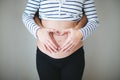 Heart wirh couple hands on the pregnant belly Royalty Free Stock Photo