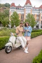 Couple making a stop for texting while riding a scooter Royalty Free Stock Photo