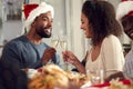 Couple Making Toast As Multi Generation Family In Paper Hats Enjoying Eating Christmas Meal At Home Royalty Free Stock Photo