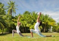 Couple making yoga in low lunge pose outdoors Royalty Free Stock Photo