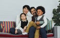 Couple male gay taking care with love to adopted children who are little diverse Caucasian and African girl and boy, sitting on Royalty Free Stock Photo