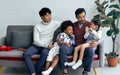 Couple male gay taking care with love to adopted children who are little diverse Caucasian and African girl and boy, sitting on Royalty Free Stock Photo