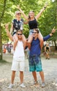 Couple, man and carrying woman on shoulders at music festival with cheers for celebration in woods. Happy, people or Royalty Free Stock Photo