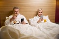 Couple of man with croissants and smiling woman with juice using smartphones Royalty Free Stock Photo