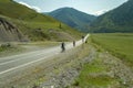 A couple of man and woman in helmets ride on sports bicycles on