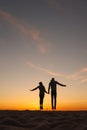 couple of man and woman holding hands jumping on background of the sky. sunset walk on seashore Royalty Free Stock Photo