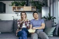 Couple man and woman at home watching TV together, bored switching channels, trying to find an interesting channel, family sitting Royalty Free Stock Photo