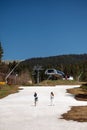 Couple man and woman in light casual clothes walking on the snow in the mountain resort, climbing the mountains. Vertical Royalty Free Stock Photo