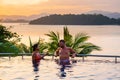 couple man and woman mid age in swimming pool on a luxury vacation in Thailand, men and Asian woman in pool looking out Royalty Free Stock Photo