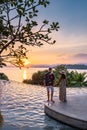 couple man and woman mid age in swimming pool on a luxury vacation in Thailand, men and Asian woman in pool looking out Royalty Free Stock Photo