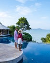 couple man and woman mid age in swimming pool on a luxury vacation in Thailand, men and Asian woman in pool looking out Royalty Free Stock Photo