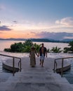 couple man and woman mid age in swimming pool on a luxury vacation in Thailand, men and Asian woman in pool looking out Royalty Free Stock Photo