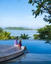 couple man and woman mid age in swimming pool on a luxury vacation in Thailand, men and Asian woman in pool looking out Royalty Free Stock Photo