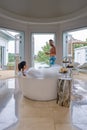 Couple man and woman mid age on vacation in luxury resort sitting in the bath tub looking ocean, European man and Asian Royalty Free Stock Photo