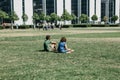 Couple man and woman relax on the grass in the park on a sunny day and communicate with each other.