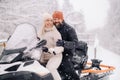 A couple, a man and a woman, on a snowmobile in a winter forest Royalty Free Stock Photo
