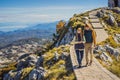 Couple man and woman tourists in mountain landscape at national park Lovcen, Montenegro. Travel to Montenegro concept Royalty Free Stock Photo