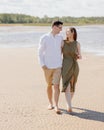 a couple of a man and a woman are walking on the beach or running along the sand along the seashore. beautiful and young Royalty Free Stock Photo