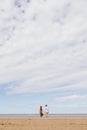 a couple of a man and a woman are walking on the beach or running along the sand along the seashore. beautiful and young Royalty Free Stock Photo