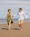 a couple of a man and a woman are walking on the beach or running along the sand along the seashore. beautiful and young Royalty Free Stock Photo